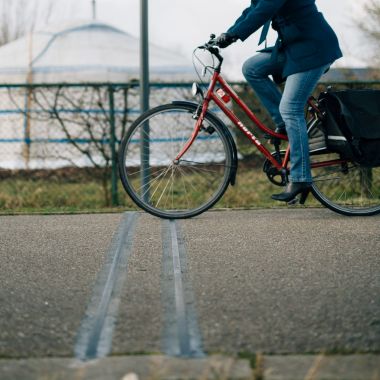 Een fietser rijdt over de telslang bij een vast telapparaat.