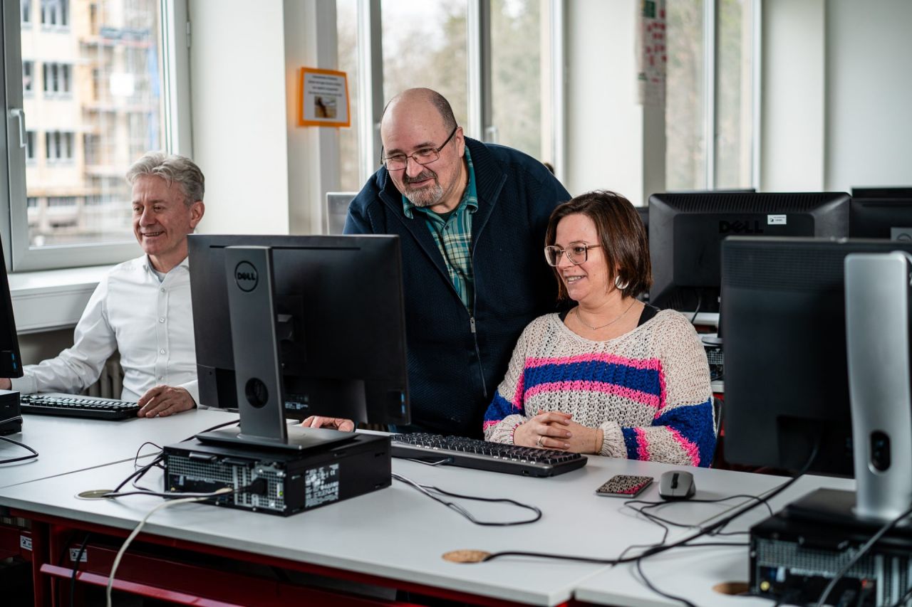 Een leerkracht geeft uitleg aan een cursist aan de computer