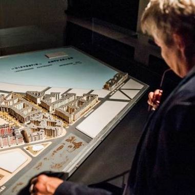 Bezoeker bekijkt een maquette tijdens de tentoonstelling 'Modellenwerk'