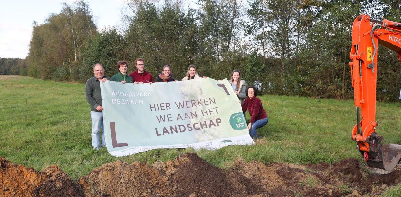 De partners van klimaatpark De Zwaan in Schoten ontvouwen een groot werfdoek bij de start van de werken.. Op het doel staat 'Klimaatpark De Zwaan. Hier werken we aan het landschap.'