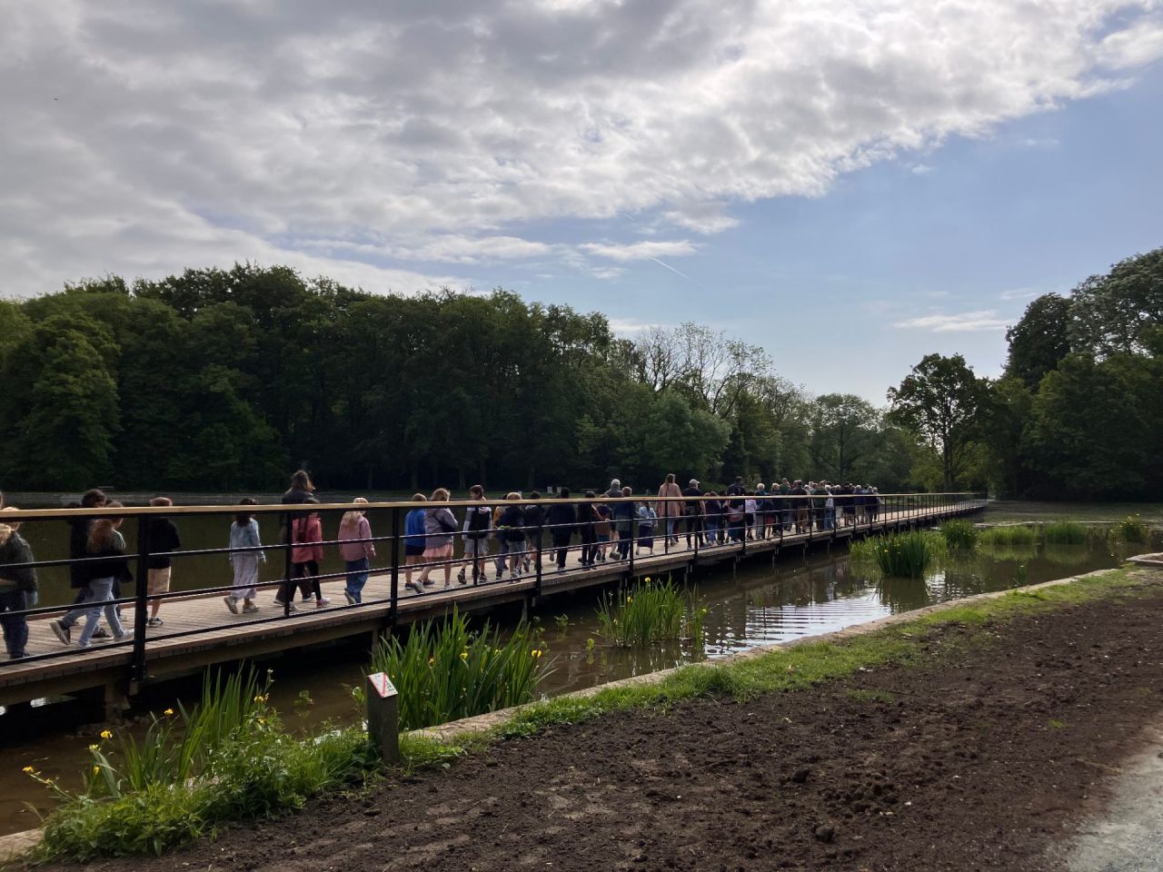 Het 3de leerjaar van basisschool De Parel loopt over de vlonderbrug.