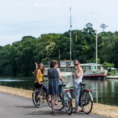 Drie dames op de fiets naast het kanaal