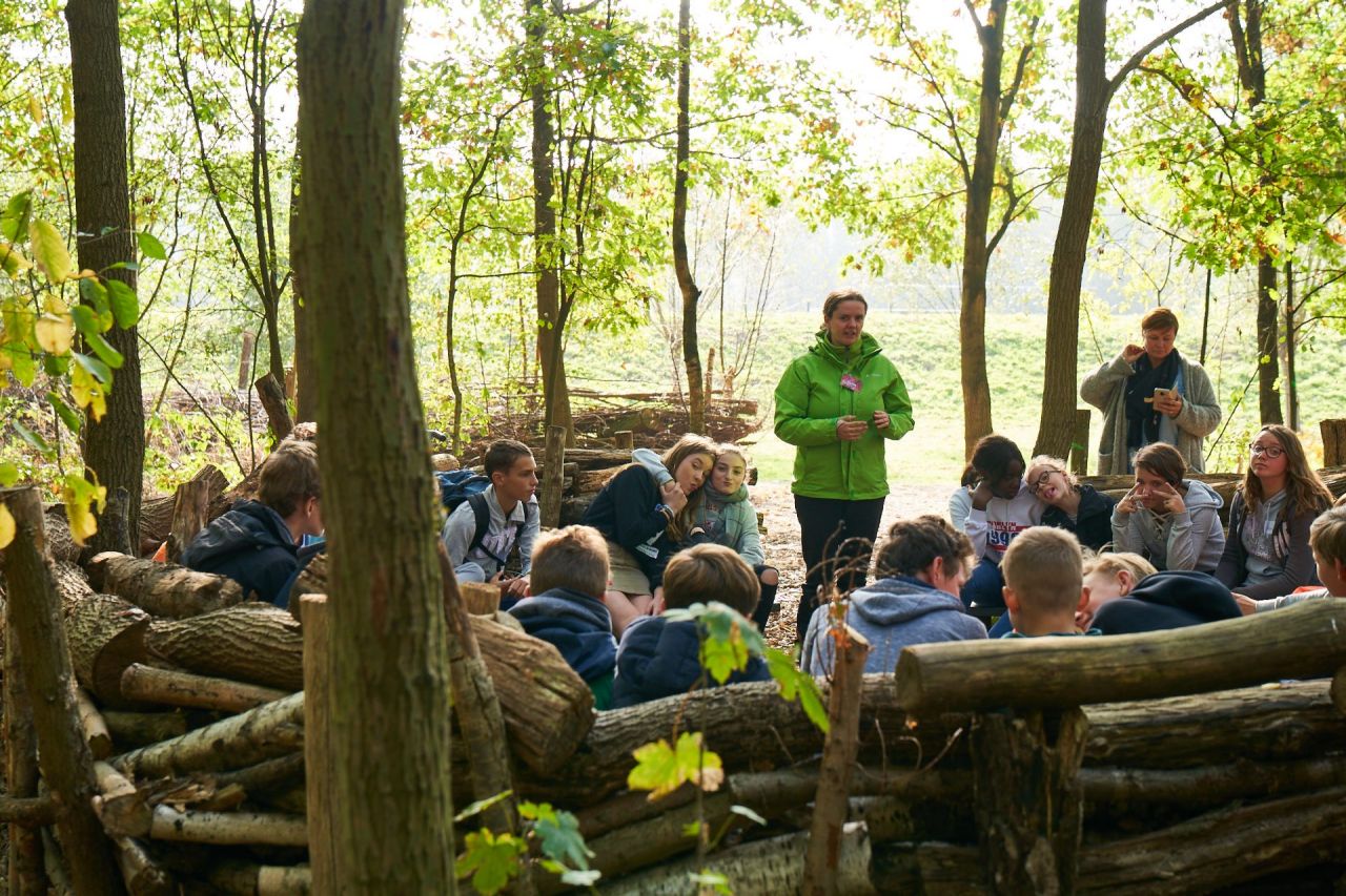 Begeleider en leerlingen in buitenklas