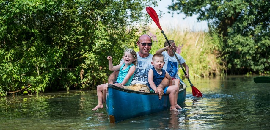 Gezellige sfeerfoto van man met drie kindjes in kano op de Kleine Nete