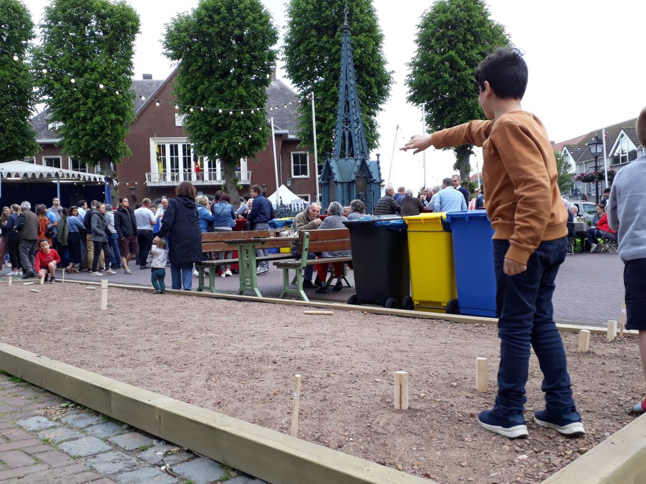 Pleintje met pratende mensen en spelende kinderen