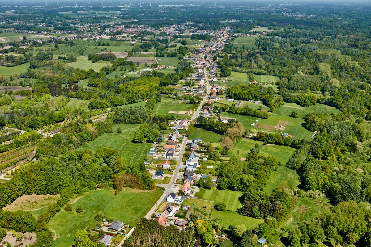 Luchtfoto van een lint met gebouwen dat een grote groene ruimte doorkruist
